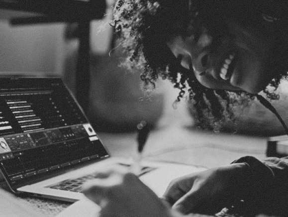 Producer smiling while working in Loopcloud on a laptop